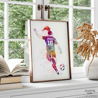 a personalised girls football player art print in a brown frame in a sunlit room