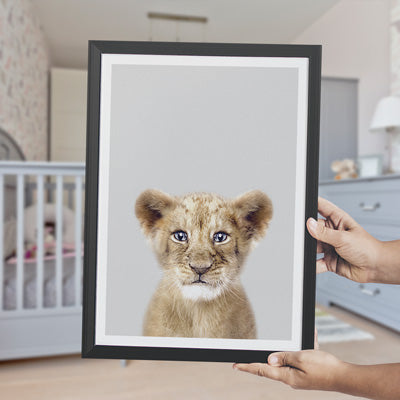 an art print of a lion cub being held in a nursery for use as décor